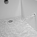 Tub filler spout in the wall of the bath