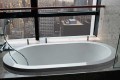 New Yorker shown as a drop-in soaking tub with a wall mounted tub filler